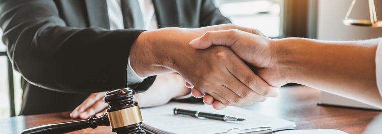 Lawyer and client shaking hands, car accident claim representation.